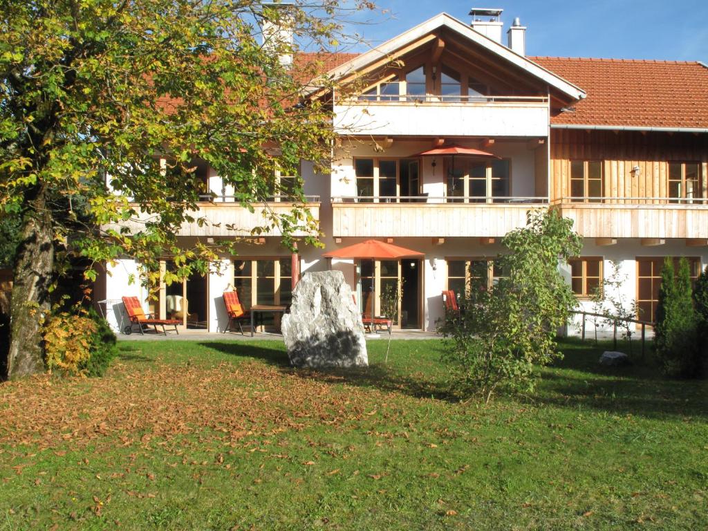伦格里斯Ferienlandhaus Alpinum的庭院里一座大房子,有大石头