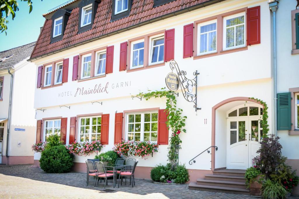 马尔克泰登费尔德Hotel Mainblick Garni的前面有桌子的建筑