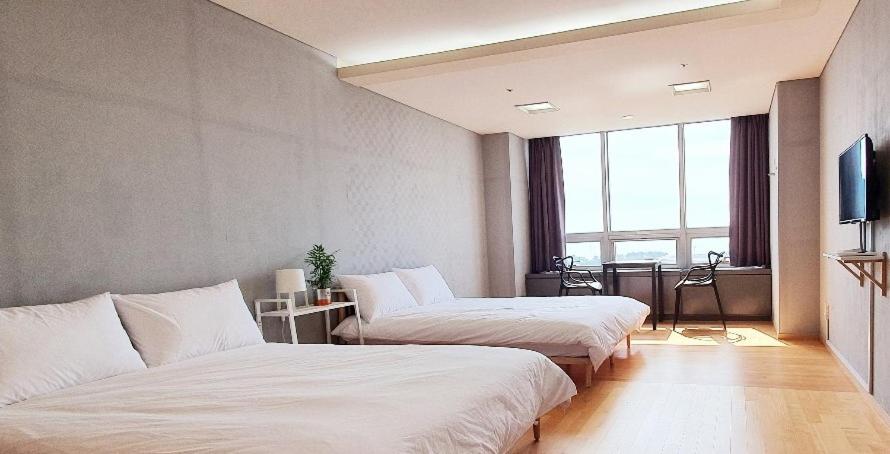 仁川市Treehouse的酒店客房设有两张床和电视。