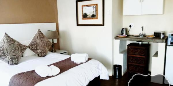 Tom BurkeThe Owl's Nest Guesthouse的卧室配有一张带两个枕头的大白色床