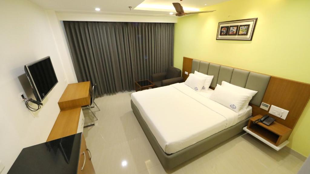 维杰亚瓦达Hotel Sri Ram Grand的酒店客房,配有床和电视