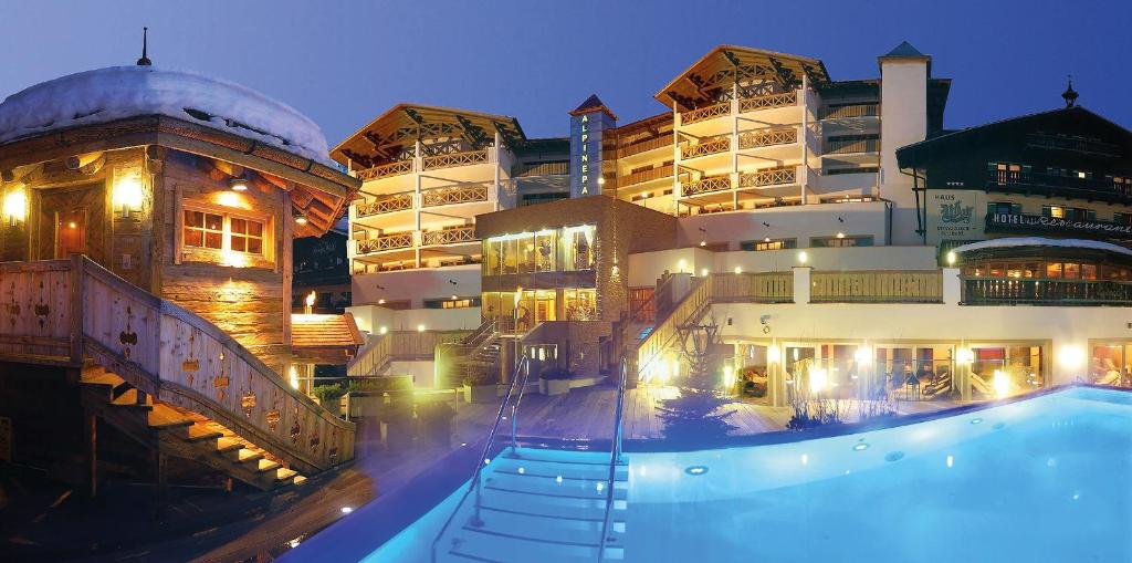 萨尔巴赫Hotel Alpine Palace的大楼前设有游泳池的酒店