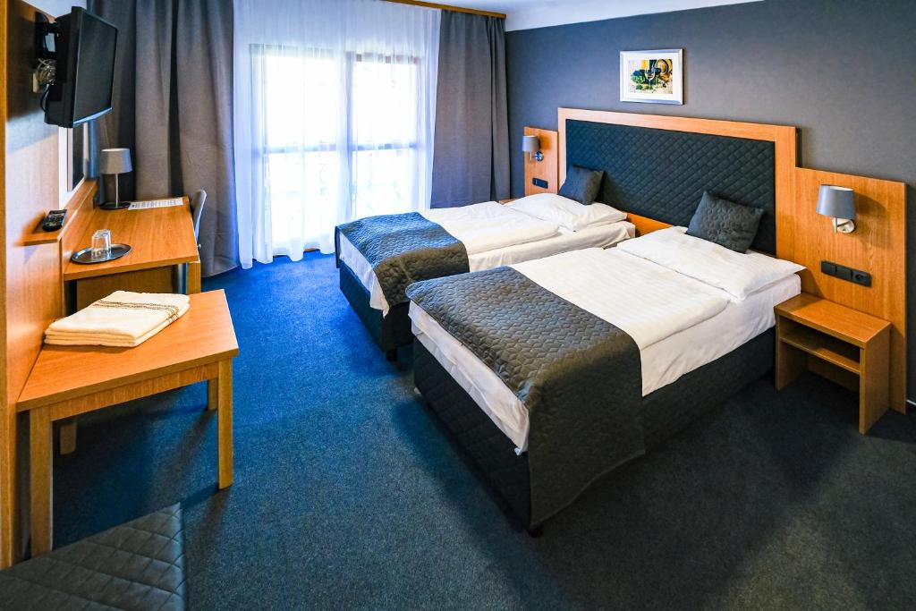 胡斯托佩切鲁斯提卡酒店的酒店客房配有两张床和一张书桌
