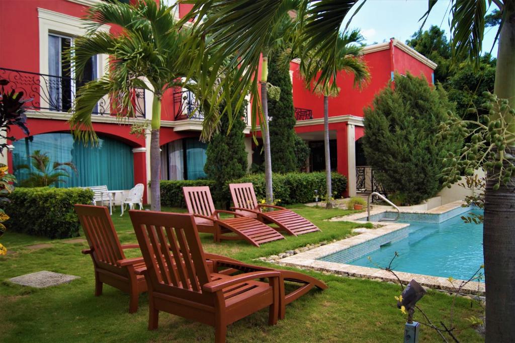 马那瓜Altos de Fontana的一组椅子,位于一个带游泳池的房子旁边