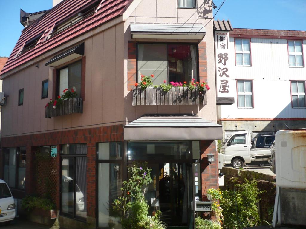 野沢野沢御宿的一座带鲜花阳台的建筑