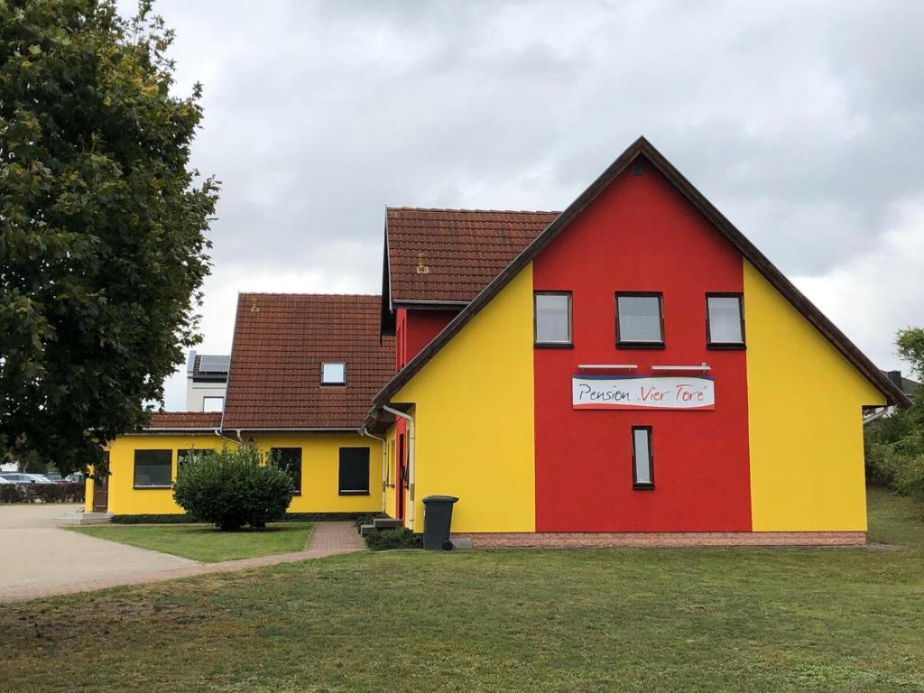 新勃兰登堡Pension ,,Vier Tore''的红色的黄色和红色的房子,上面有标志