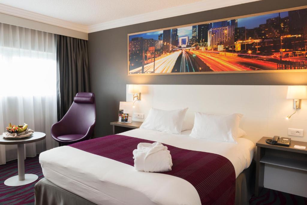 朗吉斯假日度假奥利酒店的酒店客房设有一张大床和一台电视机。