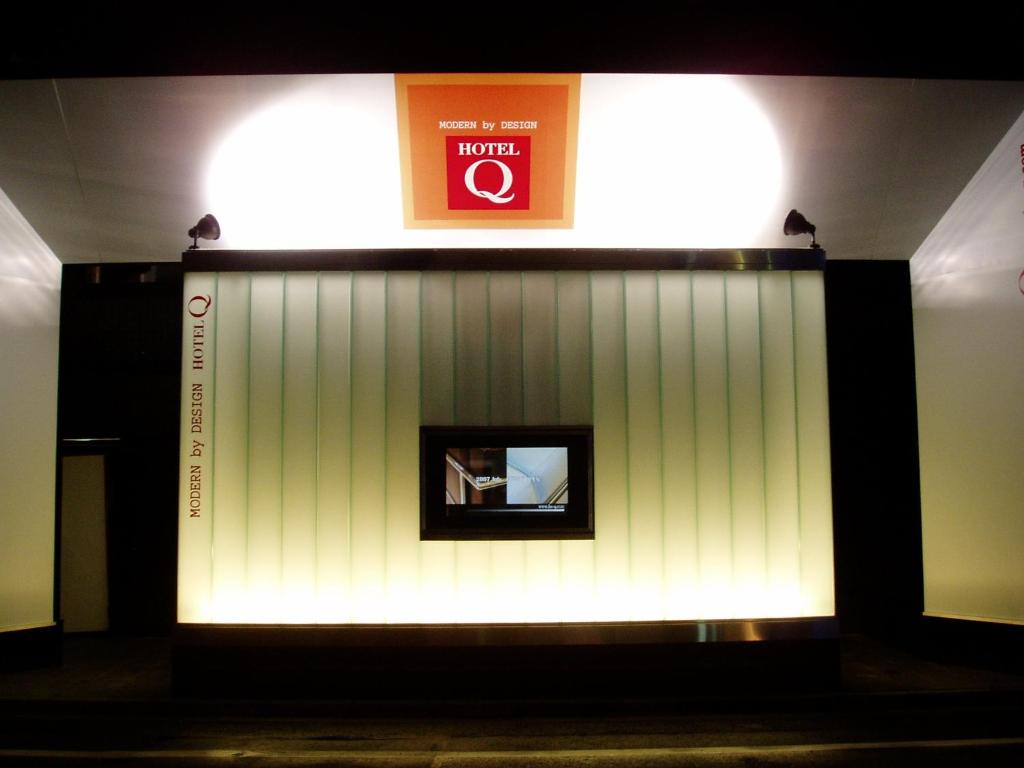 东京HOTEL Q的一间有白色墙壁的房间,上面有标志