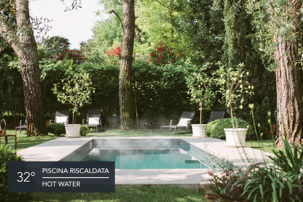 代森扎诺-德尔加达Hotel Piccola Vela的一座树木繁茂的庭院内的游泳池