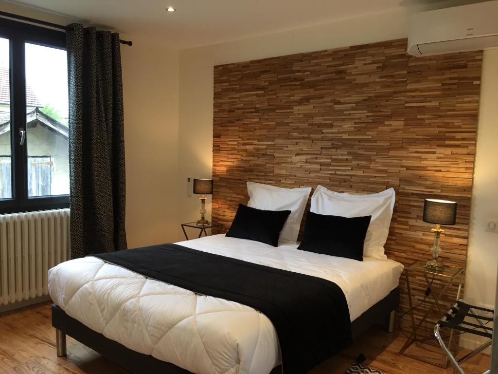 巴布哈兹LA PORTE DES ALPES的一间卧室设有一张带砖墙的大床