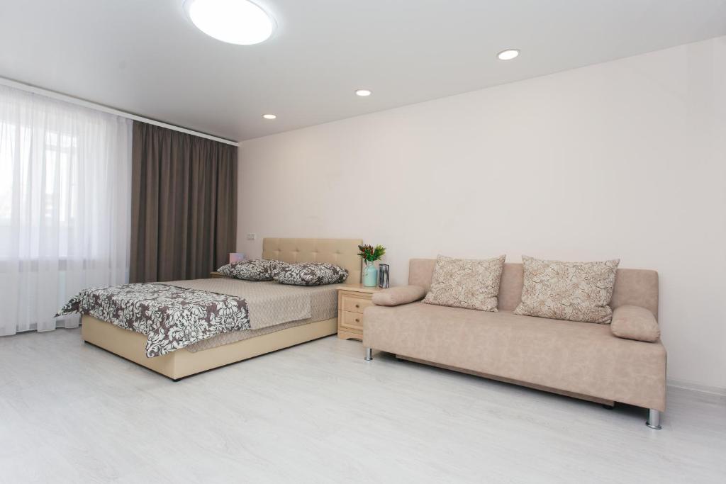 苏梅Luxury Apartment neer Manufaktura on Kharkovskaya的一间卧室配有一张床和一张沙发