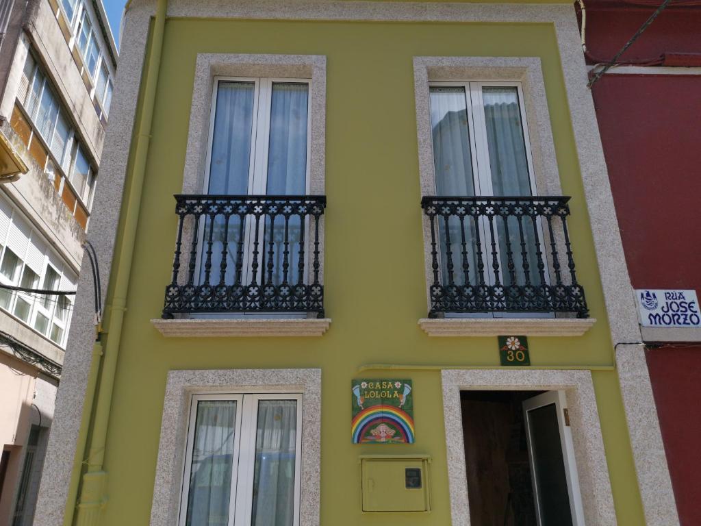 萨达Casa Lolola的街上的黄色房子,设有黑色阳台