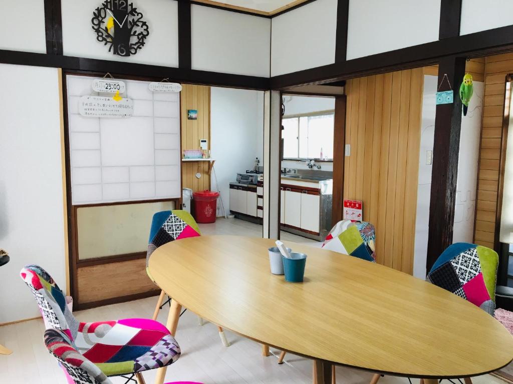 奄美Guesthouse Perche Female Only的配有木桌和椅子的教室