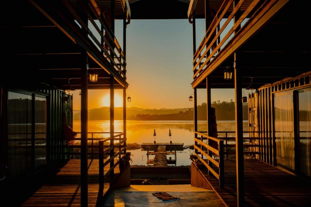 卡皮托利乌Villa Container Lodge的日落时分在水中停靠的码头