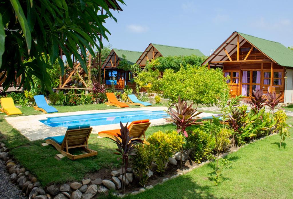 帕洛米诺Nubá Boutique Hostel Palomino的一个带游泳池和椅子的度假村