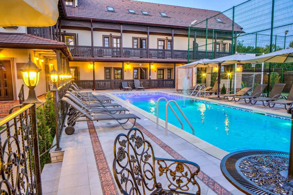 克里斯蒂安蔻娜奇奥安比恩特度假酒店的一座带长椅的游泳池,位于大楼旁
