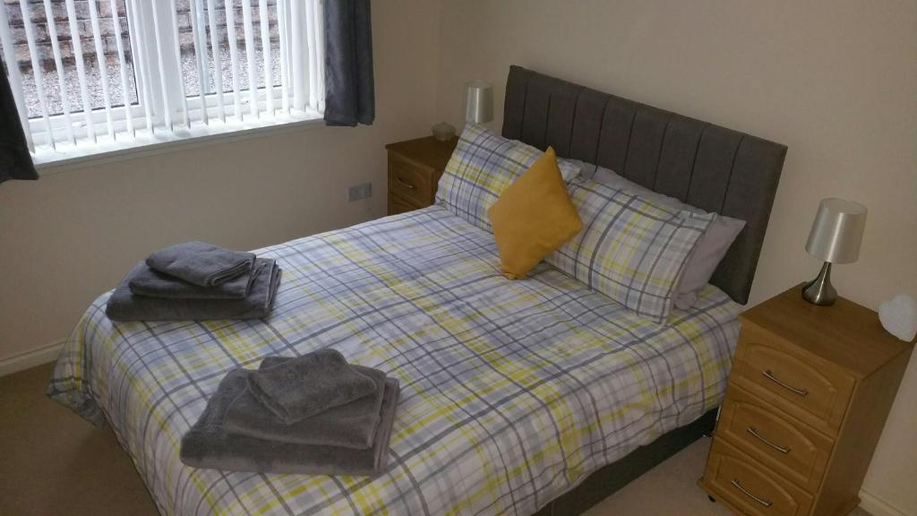因弗内斯Lerwick Garden Apartment的一间卧室配有带毛巾的床
