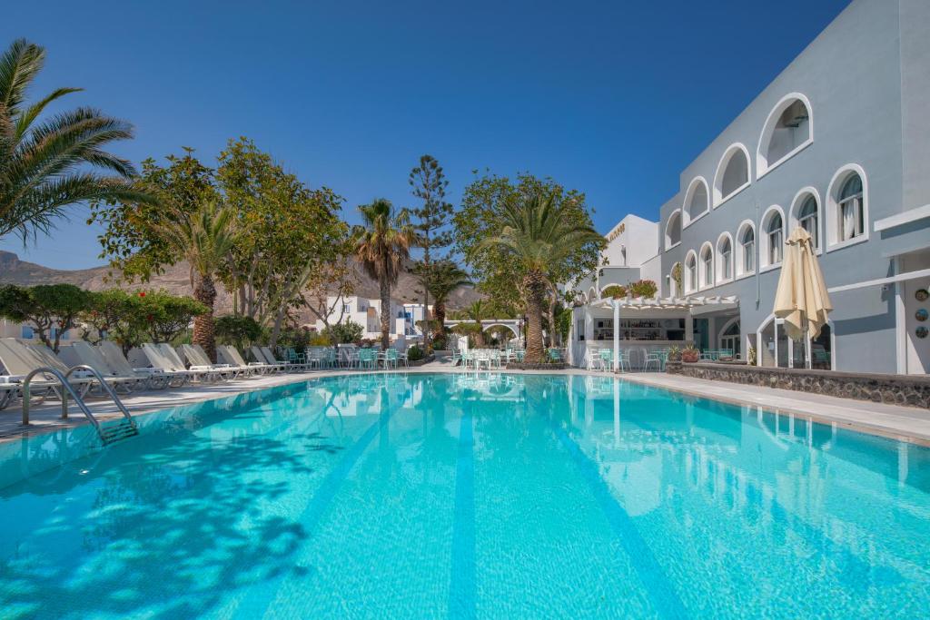 卡马利马卡里奥斯酒店的一座棕榈树大型游泳池和一座建筑