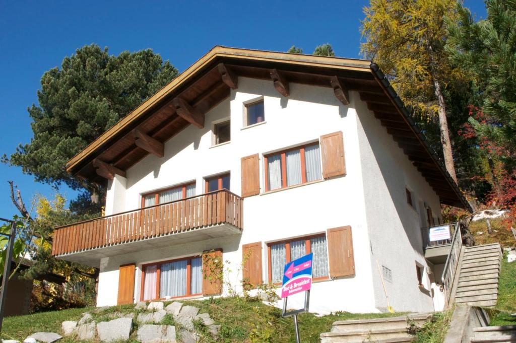 圣莫里茨B&B St Moritz的山丘上带阳台的白色房屋