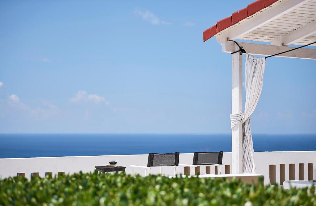 考特索纳里纳寇村公寓式酒店的一个带椅子和凉亭的庭院和大海