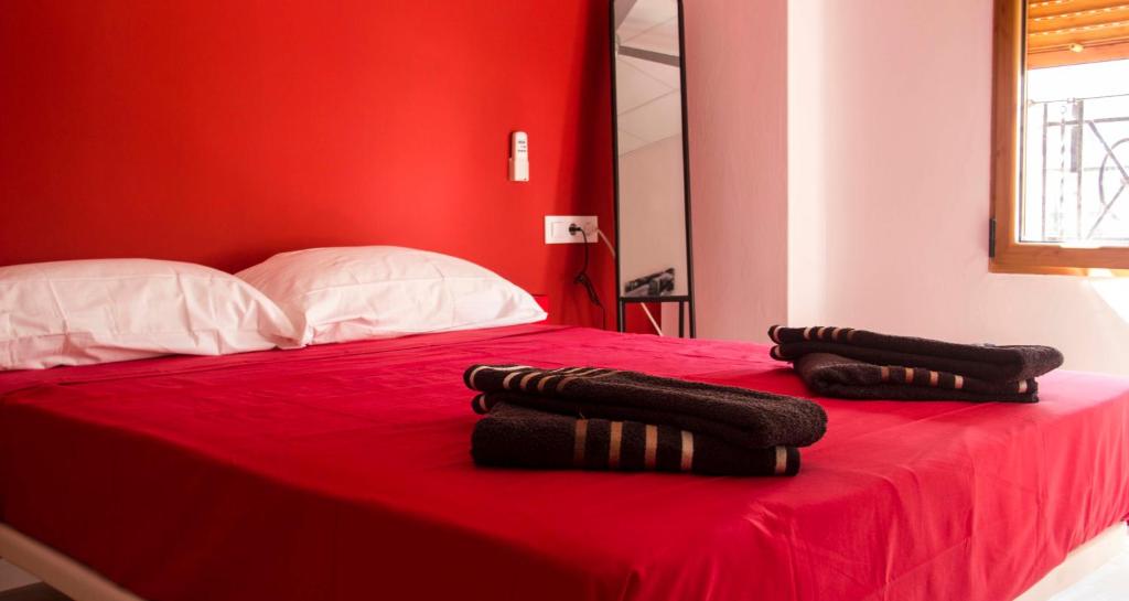 瓦伦西亚颜色客房酒店的红色卧室配有带2条毛巾的床