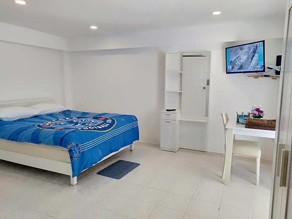罗勇Amy's beach apartments的一间卧室配有一张床、一张书桌和一台电视