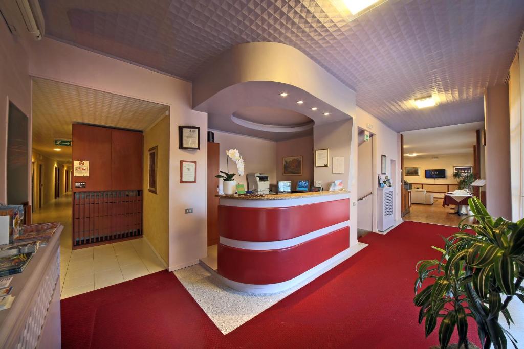 布雷西亚克丽斯塔罗布雷西亚酒店的餐厅大堂设有红色和白色的柜台