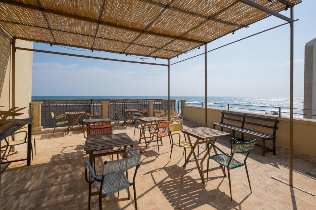 锡拉库扎古特卡欧斯基酒店的一个带桌椅的庭院和大海