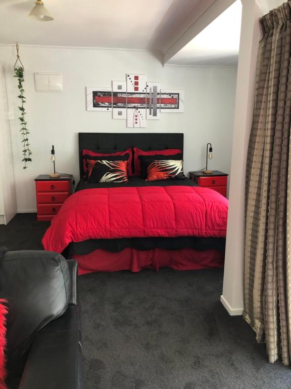 阿卡罗阿Hideaway - A Couples Retreat的卧室配有红色的床,墙上挂有篮球标志