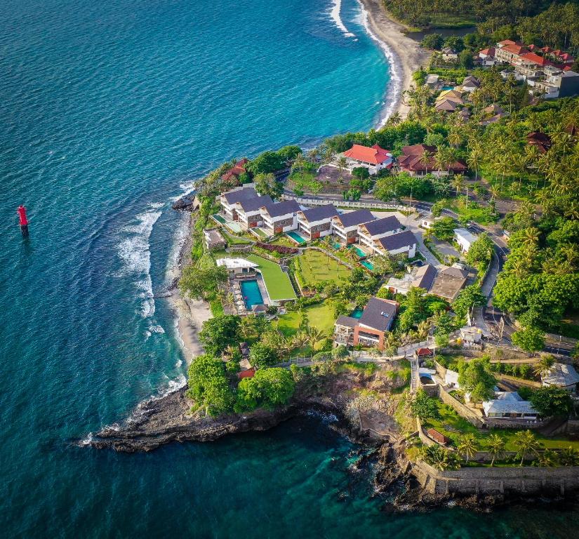 圣吉吉Rajavilla Lombok Resort - Seaside Serenity的海洋上一座房子的空中景观