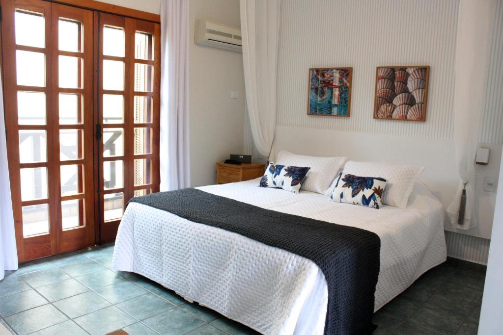 伊利亚贝拉Suite Ilhaflat的卧室配有白色的床和枕头。