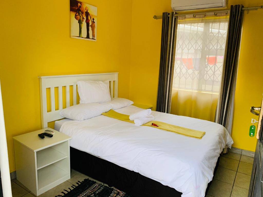 理查兹湾Sivande B&B的一间卧室设有两张带黄色墙壁和窗户的床。