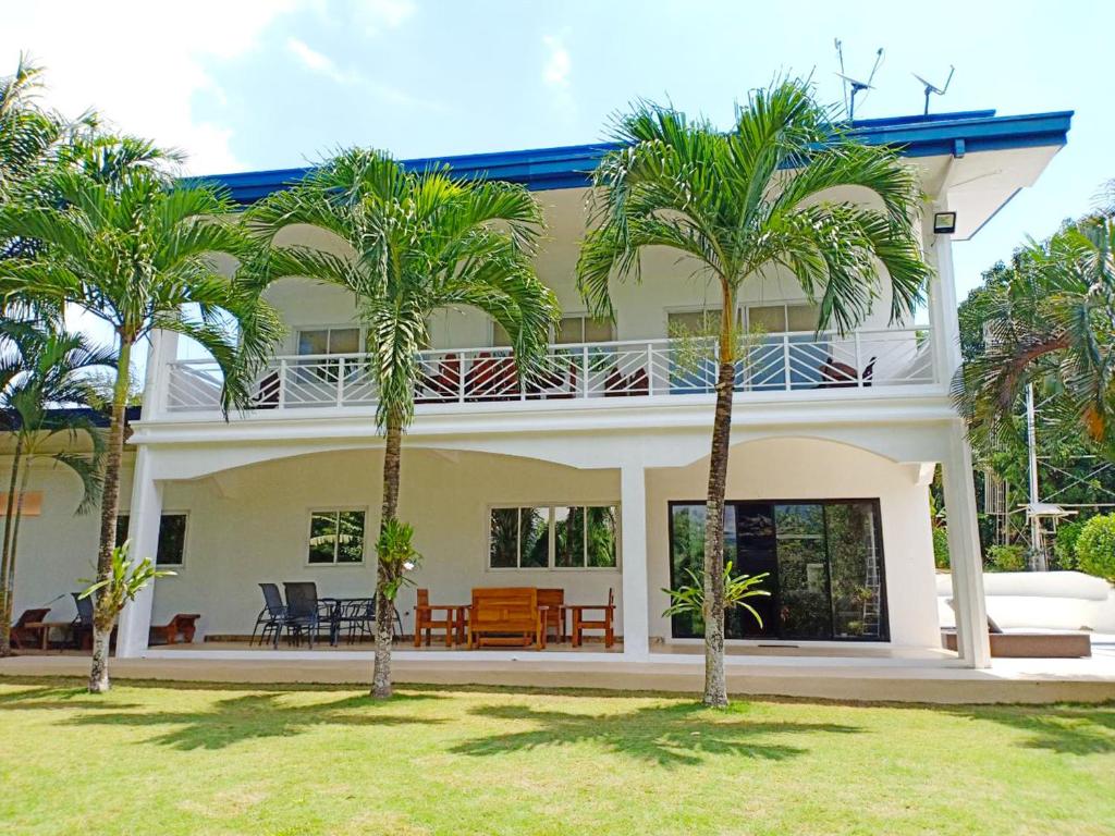 公主港热带花园游泳池奢华别墅的前面有棕榈树的房子
