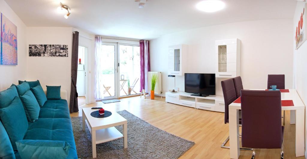 萨尔布吕肯Ferienwohnung Rodenhof的客厅配有蓝色的沙发和电视