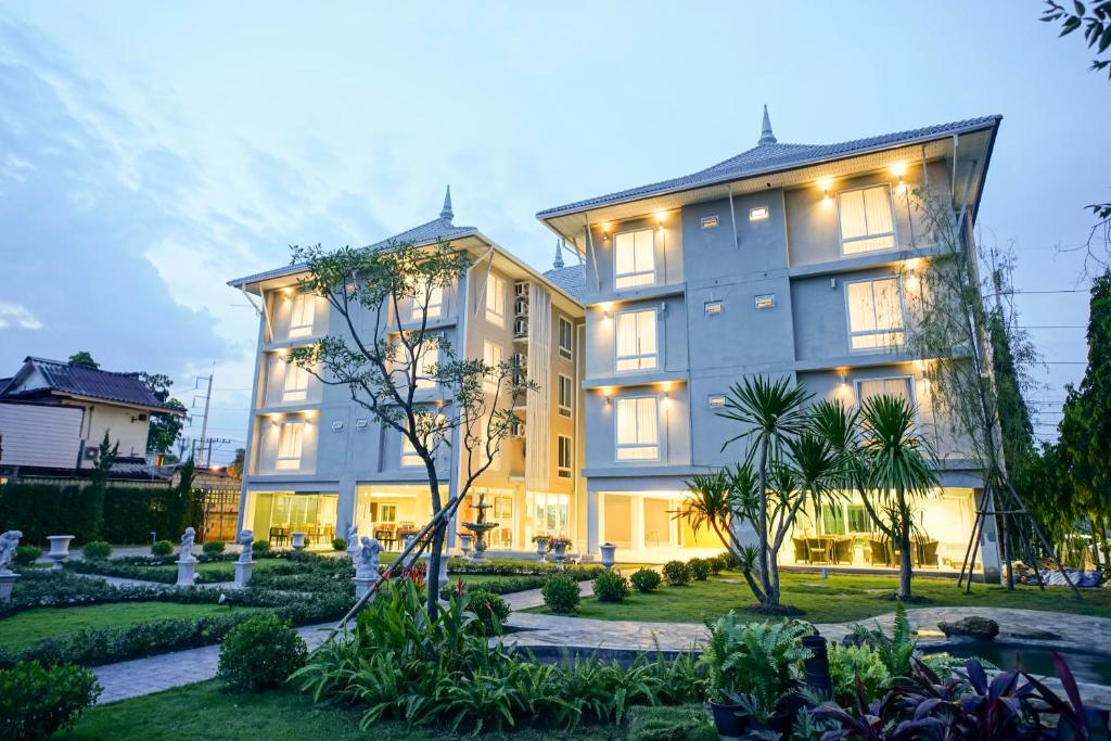 清迈Nantra Chiangmai Riverfront Hotel的一座大建筑,前面设有花园