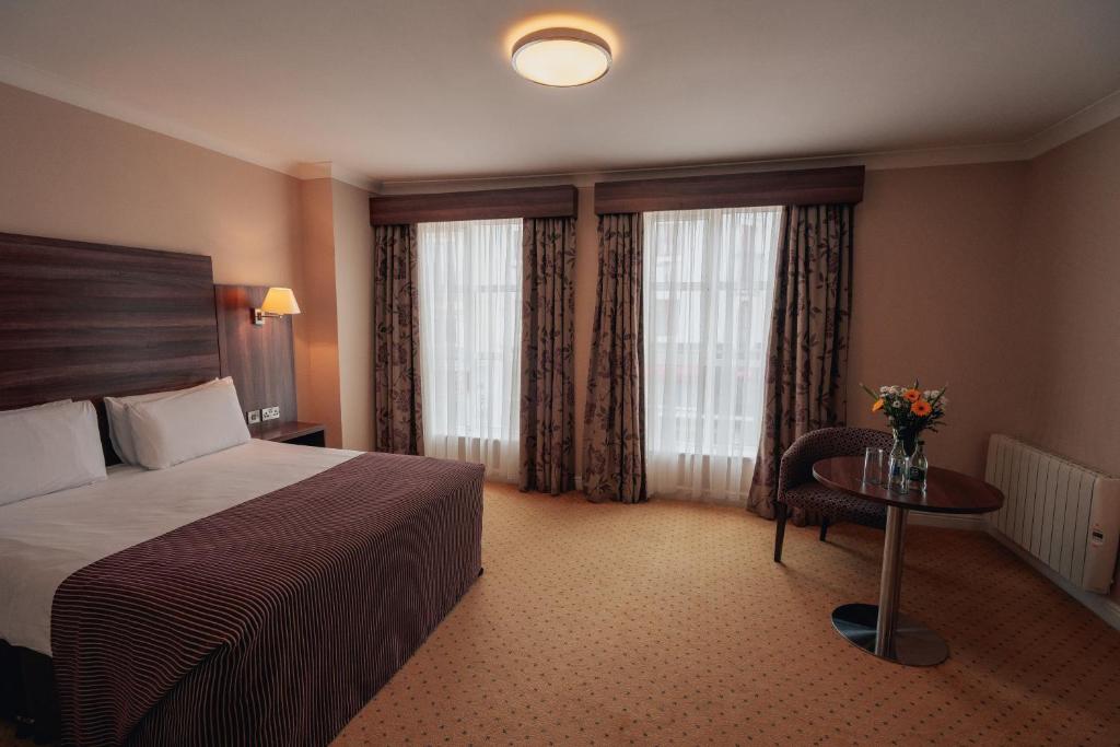 莱特肯尼迪龙酒店的酒店客房带一张床、一张桌子和窗户