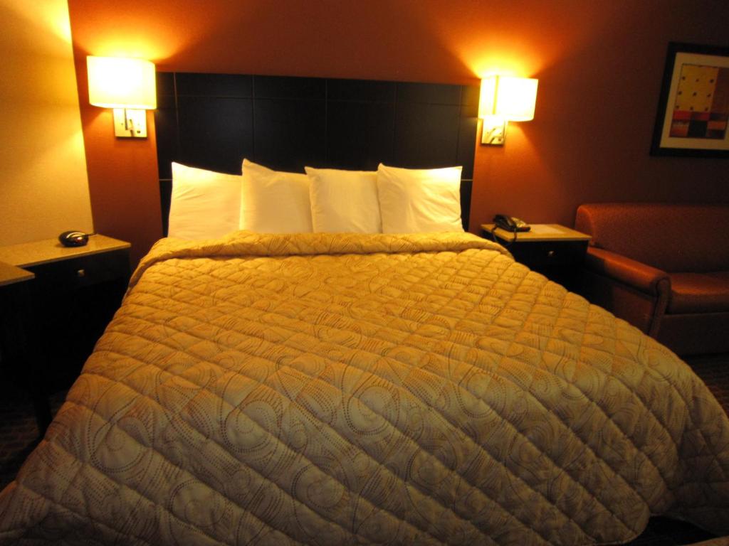 Monmouth Junction蒙默思汇合站红地毯旅店及套房酒店的一张大床,位于酒店带两盏灯的房间