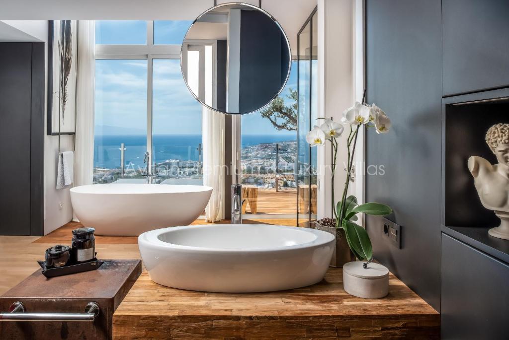 阿德耶Avitan Premium & Luxury Villas的一间带大浴缸和大窗户的浴室