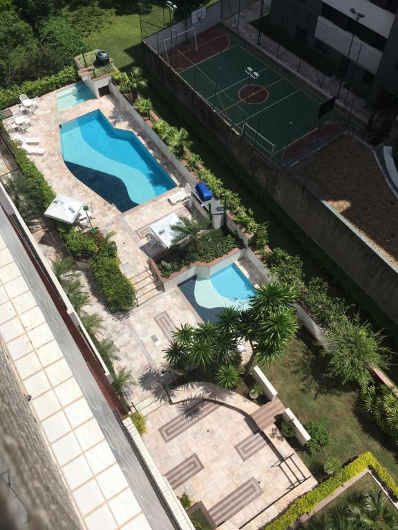 圣劳伦斯海滨Apartamento na Riviera de São Lourenço的享有游泳池和网球场的顶部景致