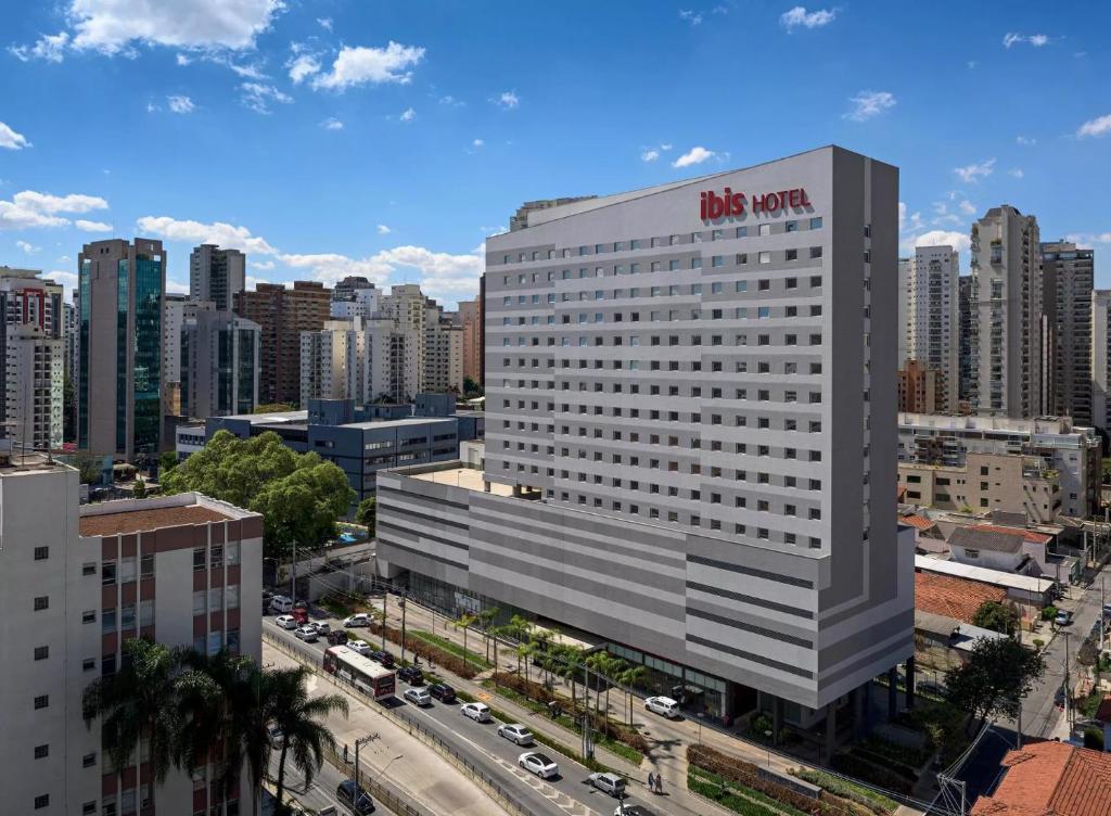 圣保罗圣保罗伊比拉布埃拉宜必思酒店的上面有 ⁇ 红标志的高大的白色建筑