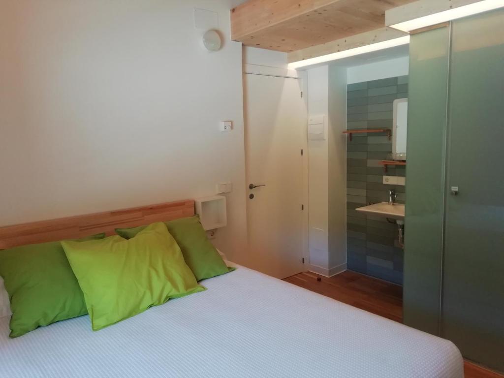 CovaneraHotel Rural Aguazul的一间卧室配有一张带绿色枕头的床和一间浴室