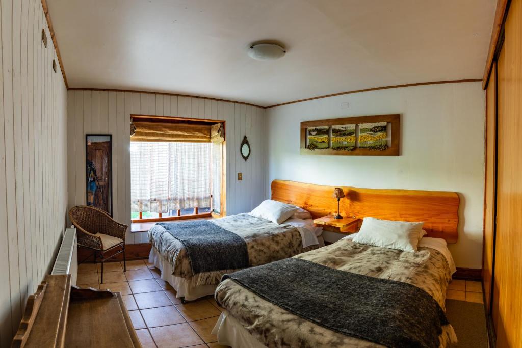普孔B&B HMüller的酒店客房设有两张床和窗户。