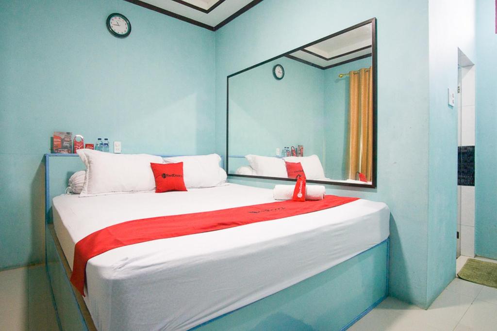 不拉士打宜RedDoorz near Mikie Holiday Funland Berastagi的一间卧室配有一张带镜子的大床