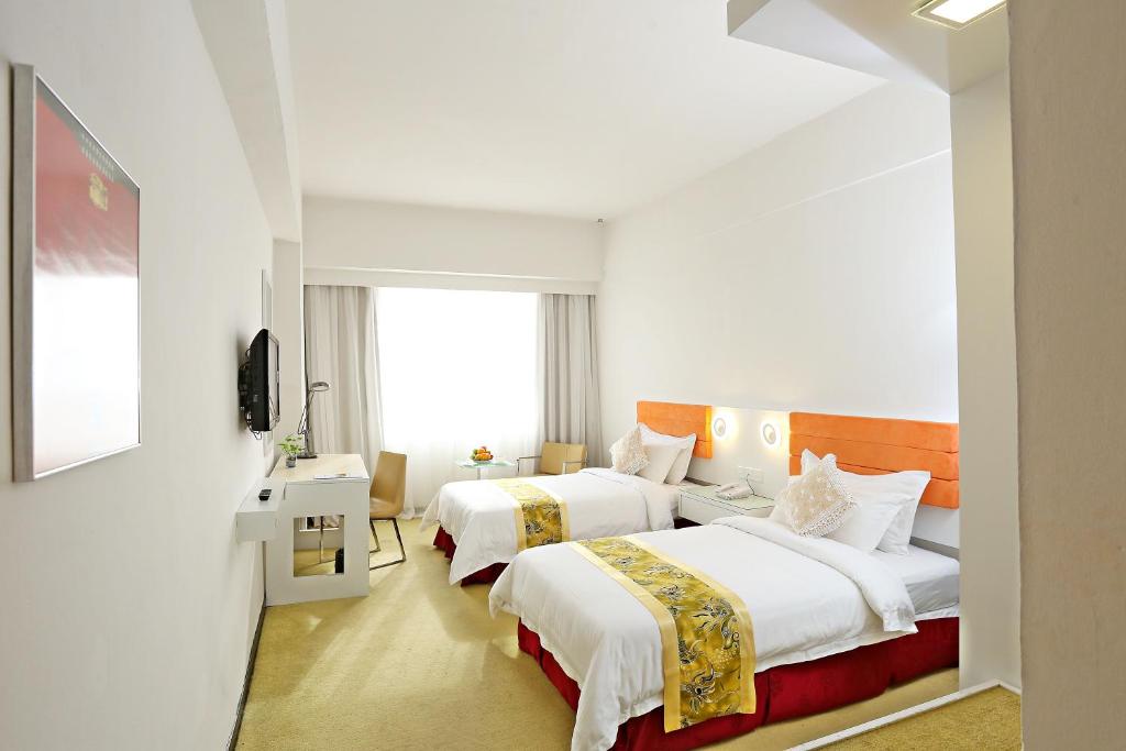 斗湖Borneo Royale Hotel的酒店客房设有两张床和电视。