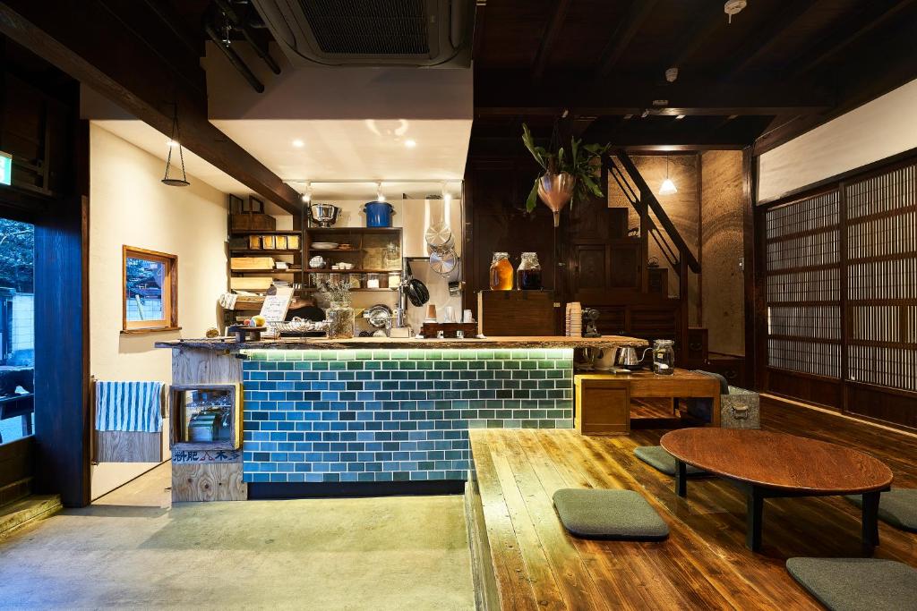 川越ちゃぶだい Guesthouse,Cafe&Bar的厨房配有蓝色瓷砖台面和桌子