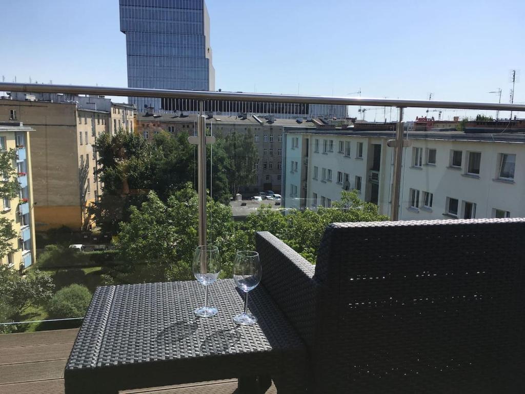 弗罗茨瓦夫Komfortowe apartamenty w centrum Wrocławia的阳台上的桌子和两杯酒杯