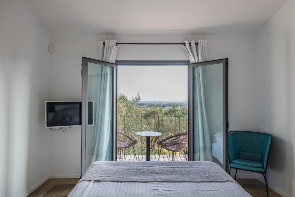 Pau玛斯拉珠莉酒店的一间卧室设有一张床和一个阳台