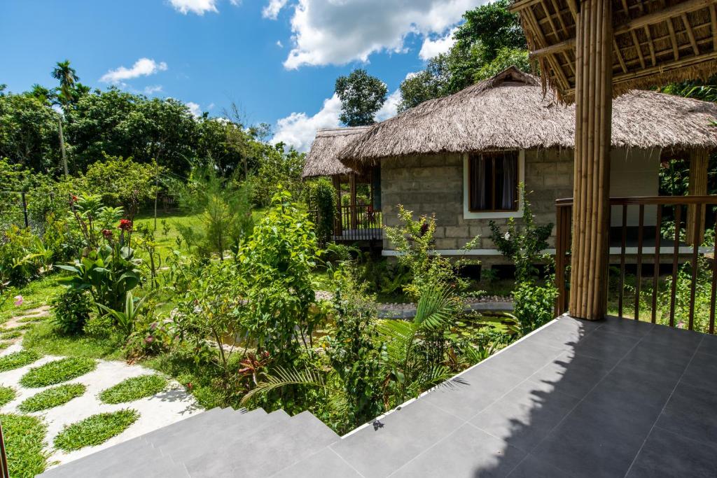 斯里曼加尔乌帕齐拉Balishira Resort Ltd.的茅草屋顶和花园的房子