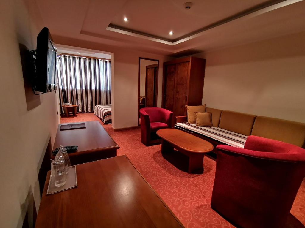波德戈里察Garni Hotel BaMBiS的酒店客房设有沙发和桌子
