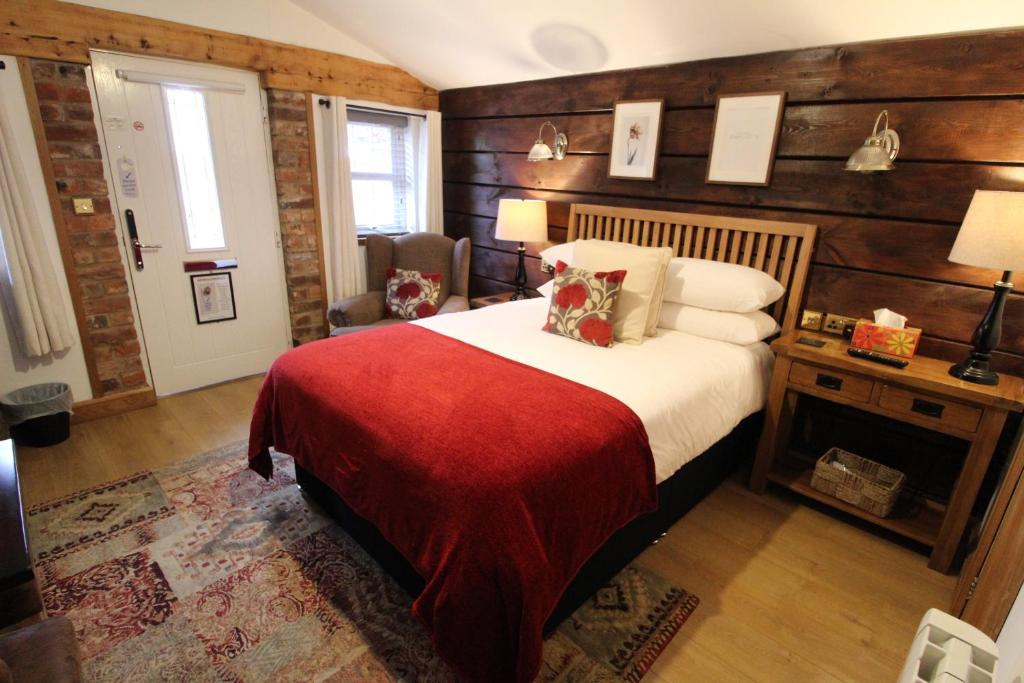 伍尔弗汉普顿Boutique Garden Lodge @ The Larches的一间卧室配有一张带红色毯子的床